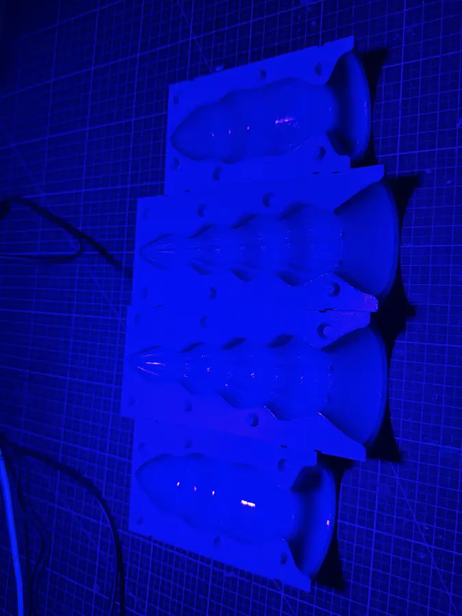 Mould halves under blue UV light while the resin hardens.