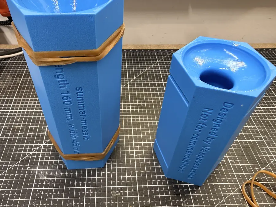 Two closed hexagonal moulds held with rubber bands. The name and size are etched on the side.