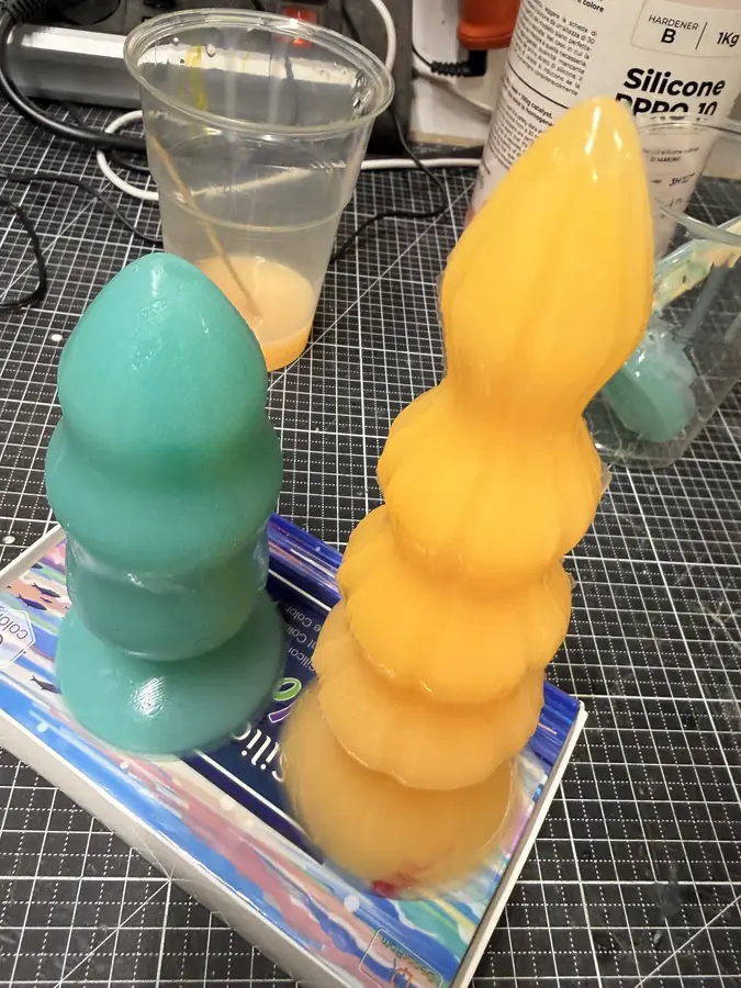 The two finished casts, one green, one yellow and ribbed, standing side by side.